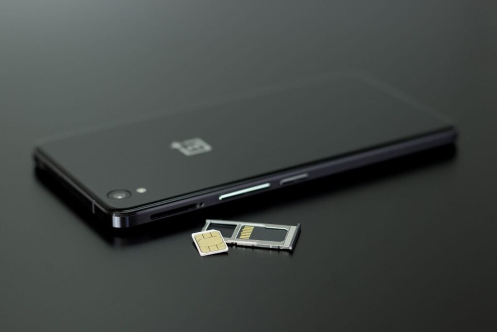 SIM-kort og mobiltelefon på mørk bakgrunn
