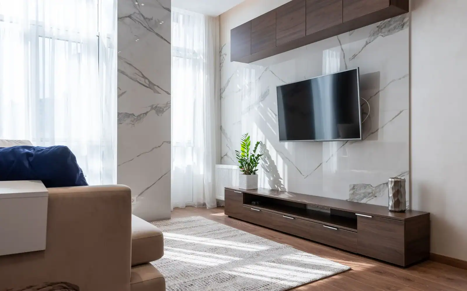 Moderne stue med TV montert på marmorvegg