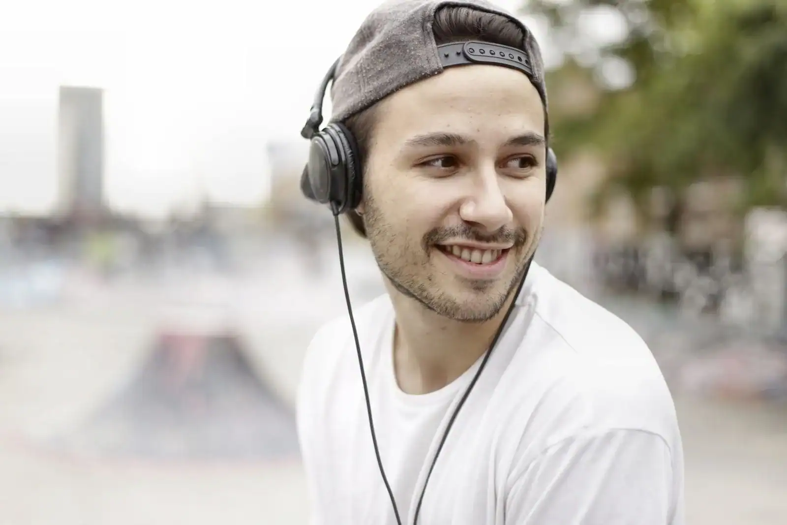 Mann med hodetelefoner lytter til musikk på mobilen