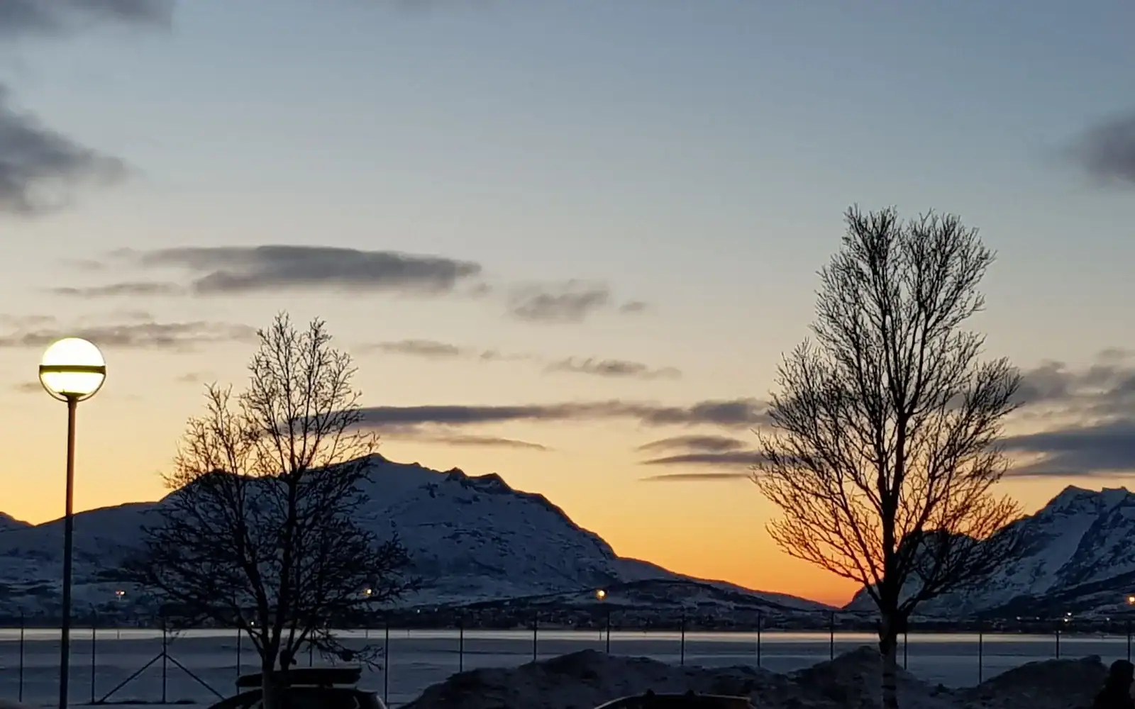 Lav vintersol over snødekte fjell og fjord i Nord-Norge