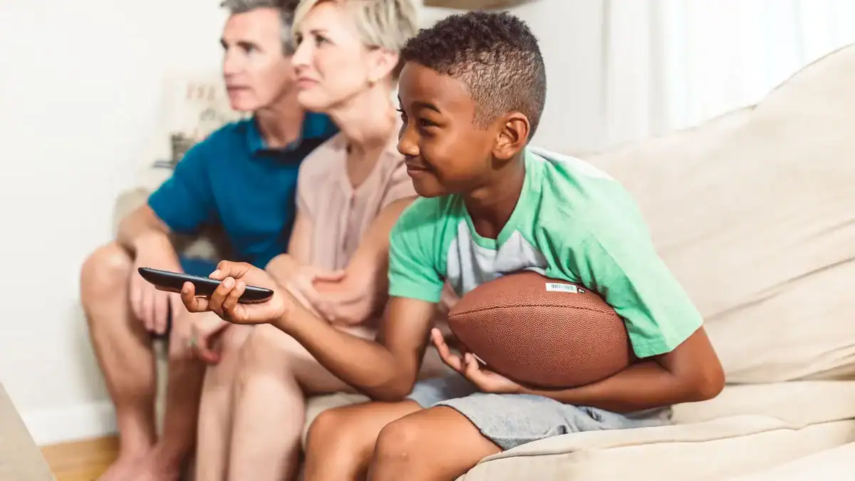 Familie i sofaen som ser på TV sammen